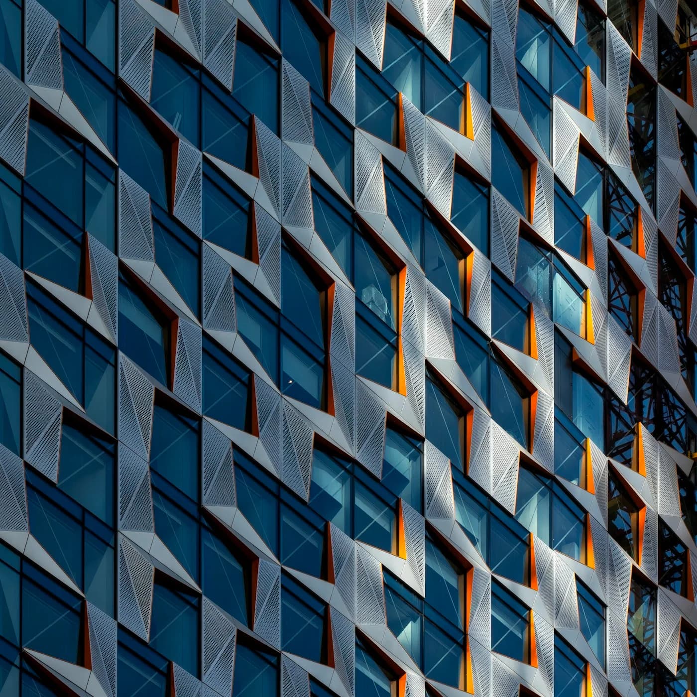 Completed contemporary building with sunlit geometric facade and glass windows